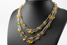Load image into Gallery viewer, a necklace of silver chains with YELLOW colored STONES on a black faux leather jewelry display bust with a white background