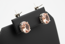 Load image into Gallery viewer, a pair of silver post back earrings with a rose gold stone on a black faux leather jewelry display with a white background