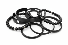 Load image into Gallery viewer, black bracelets, consisting of elastic, cuff and bangle styles, clustered together with a white background