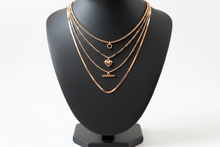 Load image into Gallery viewer, a necklace of ROSE GOLD chains on a black faux leather jewelry display bust with a white background
