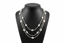 Load image into Gallery viewer, a necklace of silver chains with WHITE colored STONES on a black faux leather jewelry display bust with a white background
