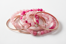 Load image into Gallery viewer, shades of pink bracelets, consisting of elastic and bangle styles, clustered together with a white background
