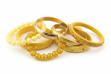 Load image into Gallery viewer, shades of yellow bracelets, consisting of elastic, cuff and bangle styles, clustered together with a white background

